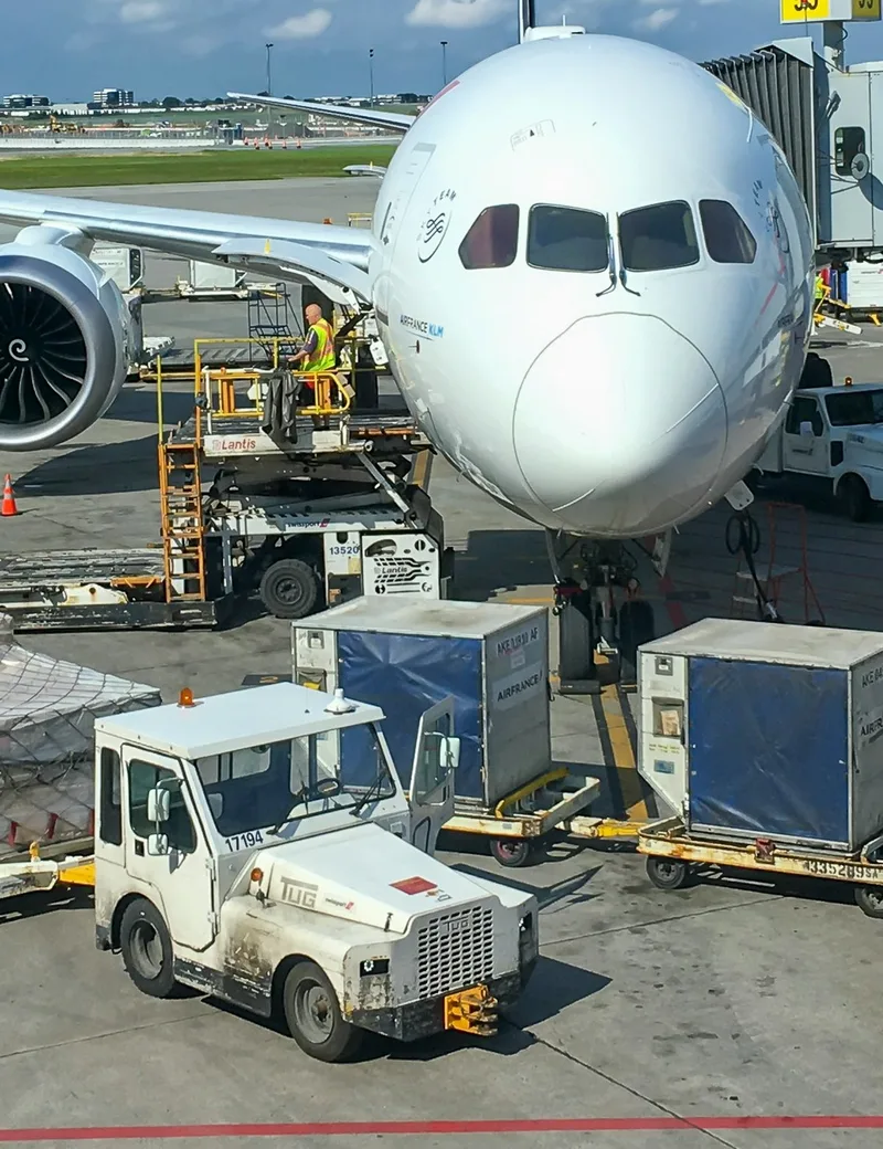 Airliner on the apron being loaded with cargo pallets and containers