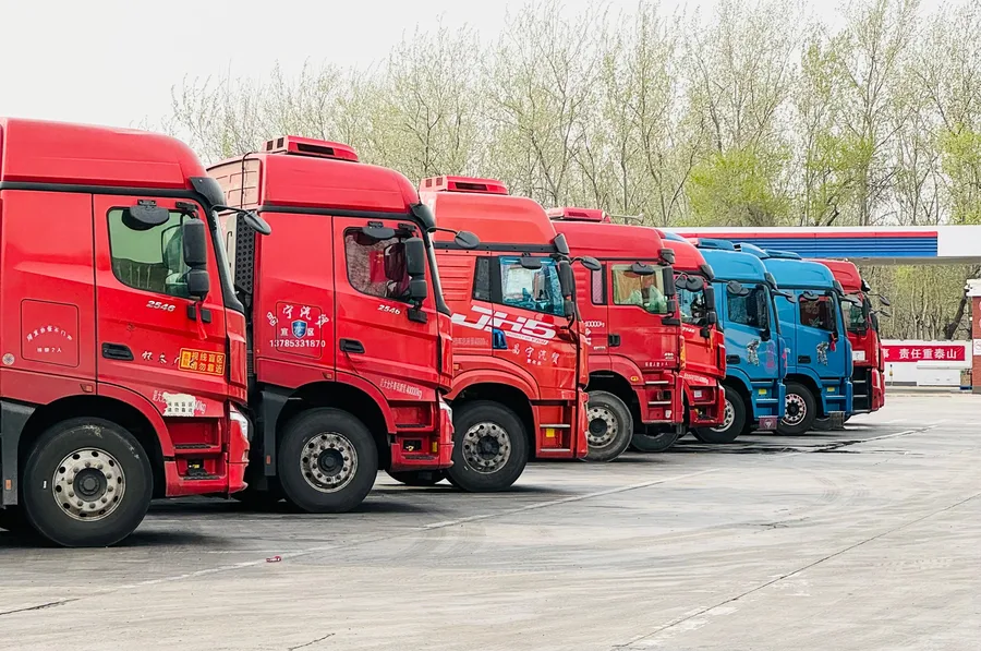 Row of heavy-duty prime mover trucks parked side by side