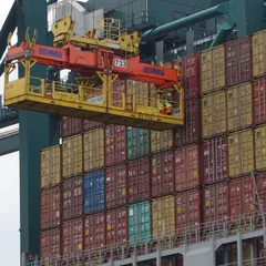Container crane lifting cargo containers at a port terminal